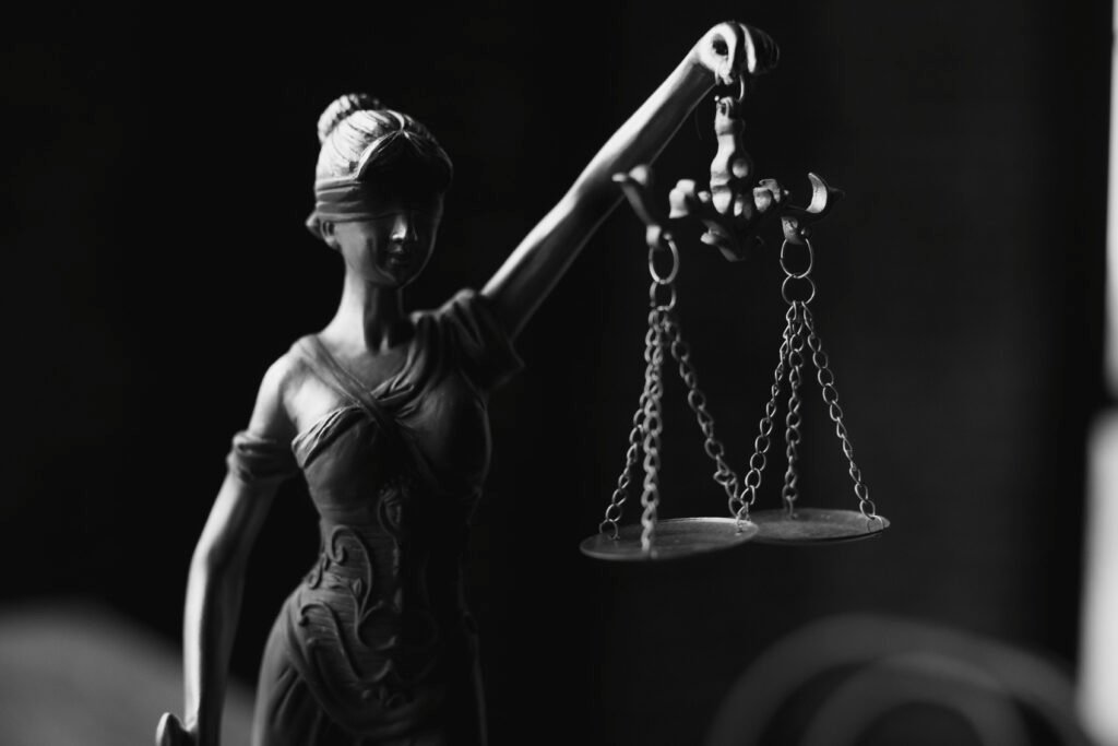 pexels-photo-6077181-6077181 A close-up black and white photo of the Lady Justice figurine with scales.